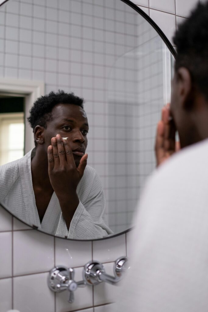 Man applying skincare product during morning acne routine