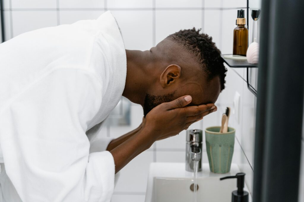 Man washing face during nighttime acne skincare routine